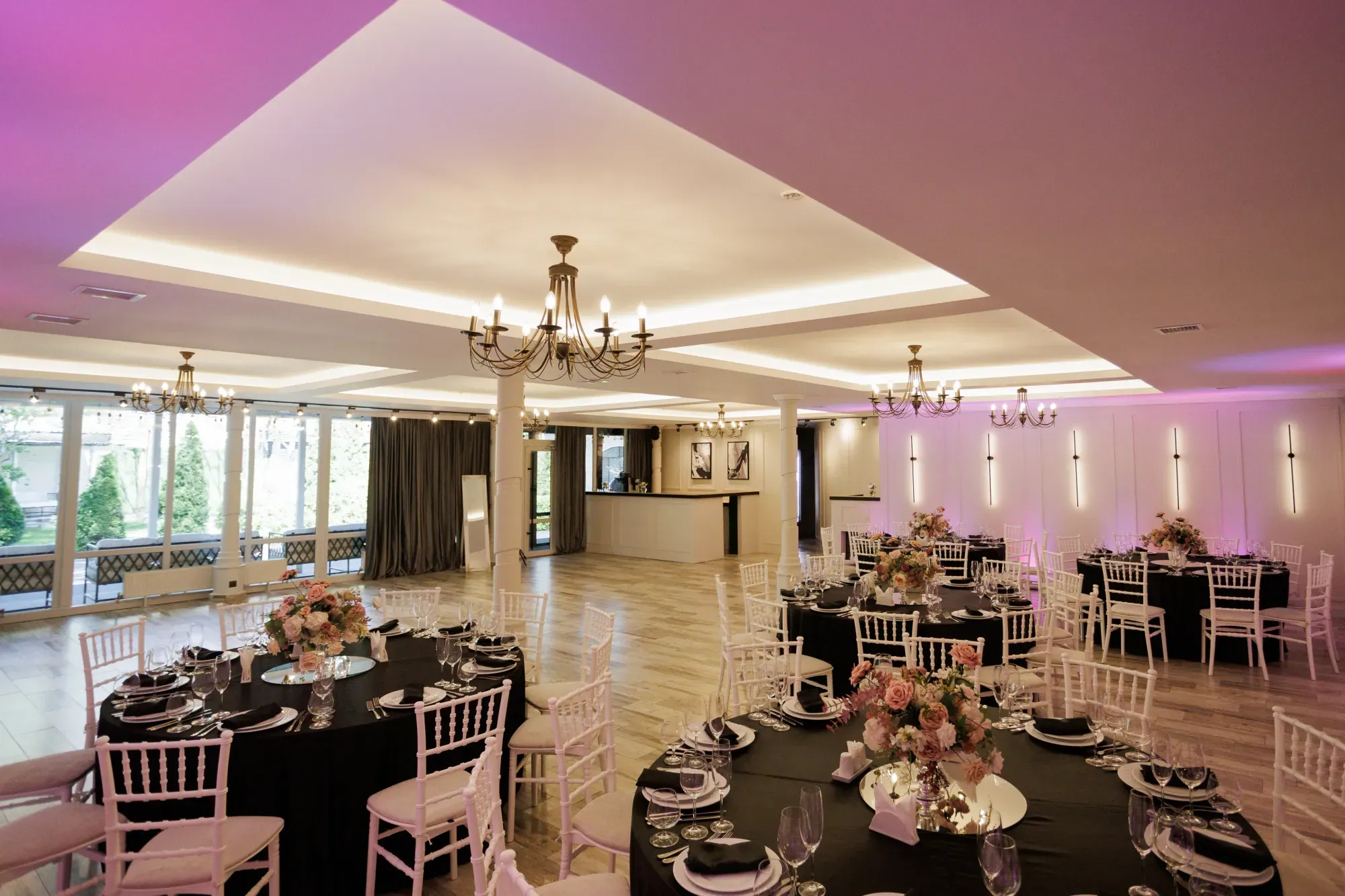 Sala Garden Palace aranjată cu mese rotunde și scaune albe, sub candelabre