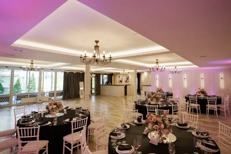 Sala Garden Palace aranjată cu mese rotunde și scaune albe, sub candelabre
