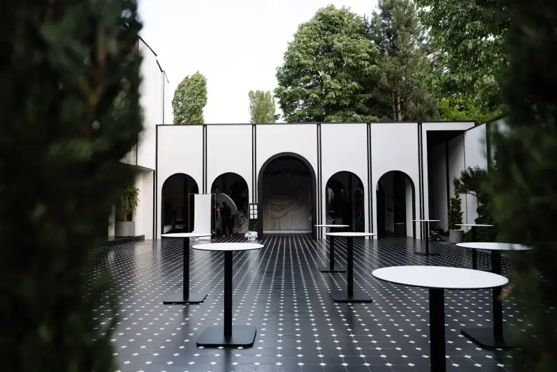 Terasa Noir de la Raymond Park, cu arcade albe și mese înalte de cocktail